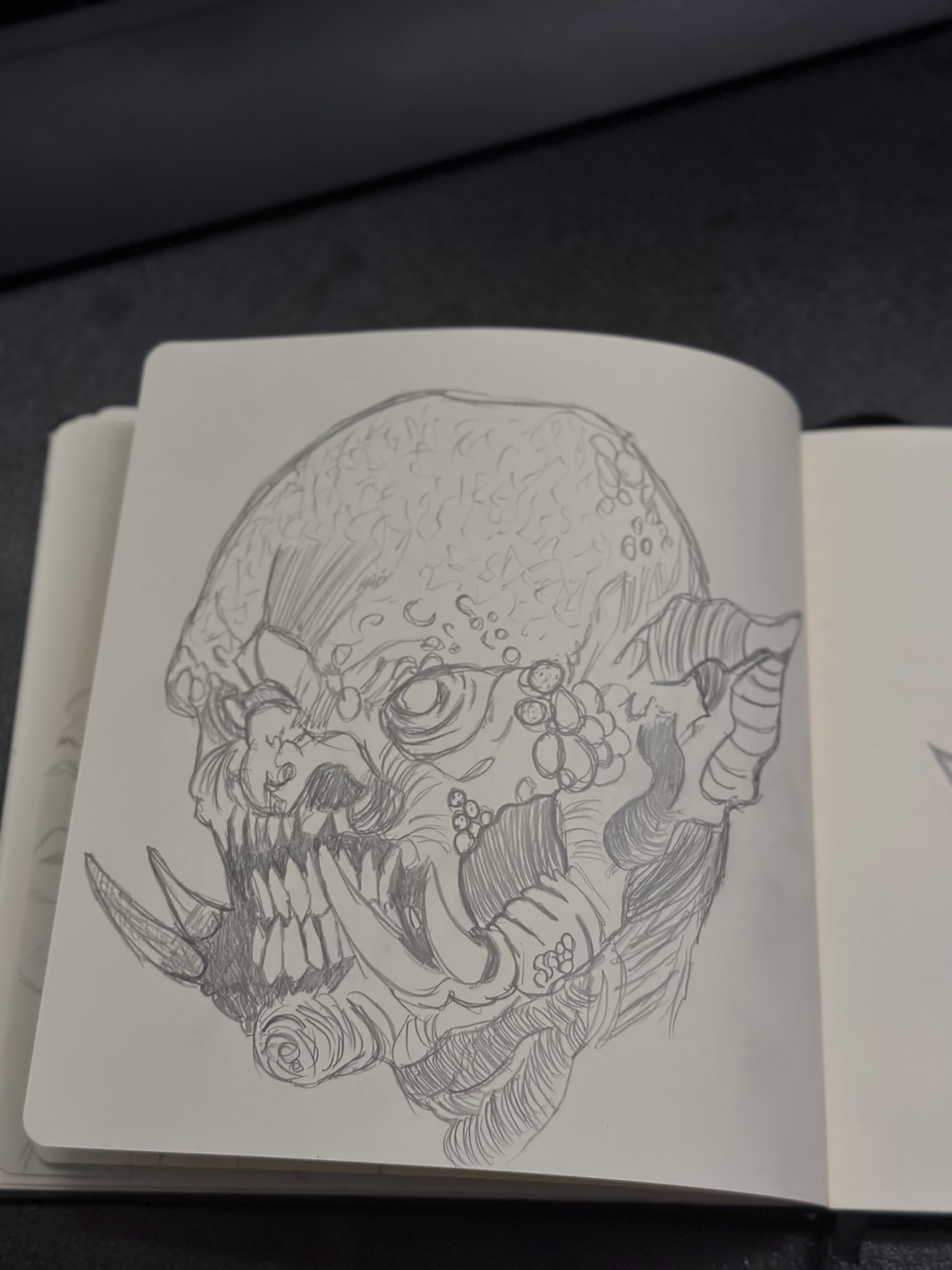 Pencil drawing of a monster skull with a wide open jaw of jagged teeth and curled horns.