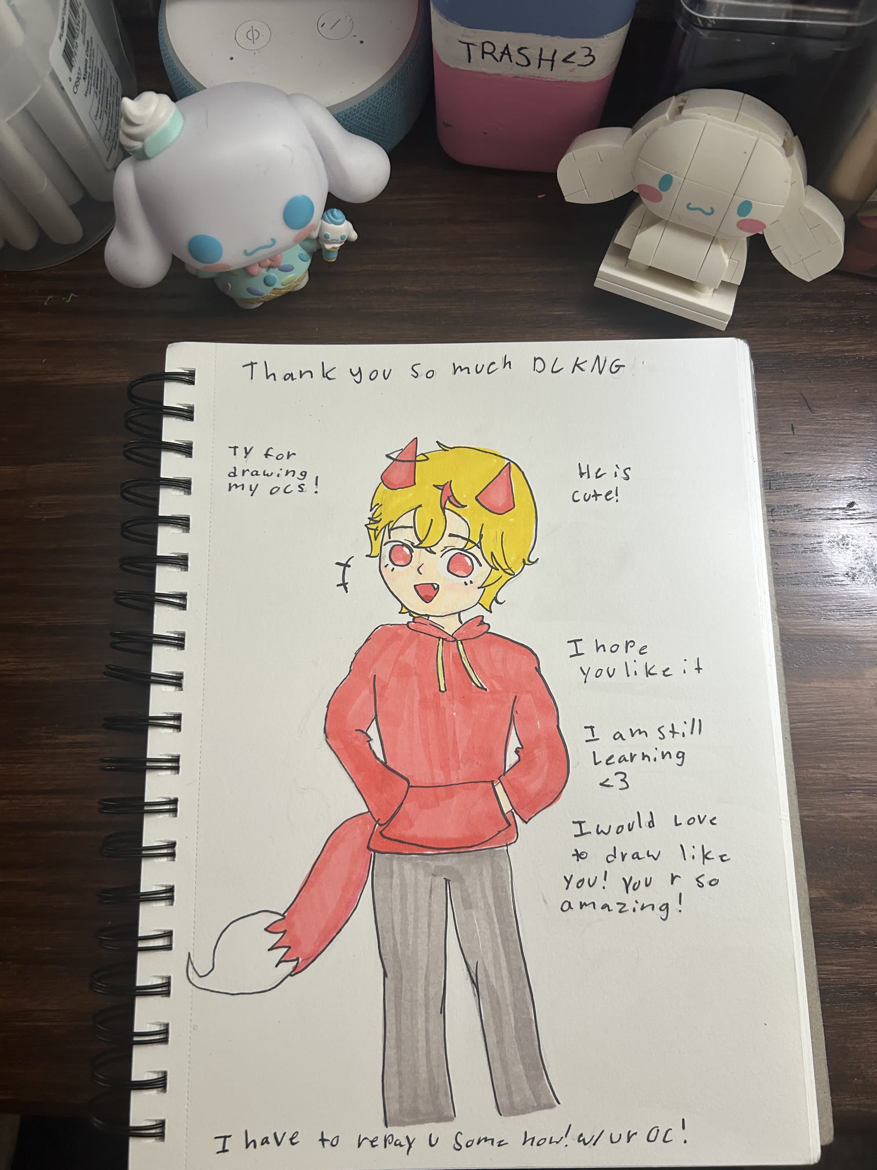 A smiling blond boy with small red horns, red hoodie and grey striped pants, hands on hips, with a fox tail.