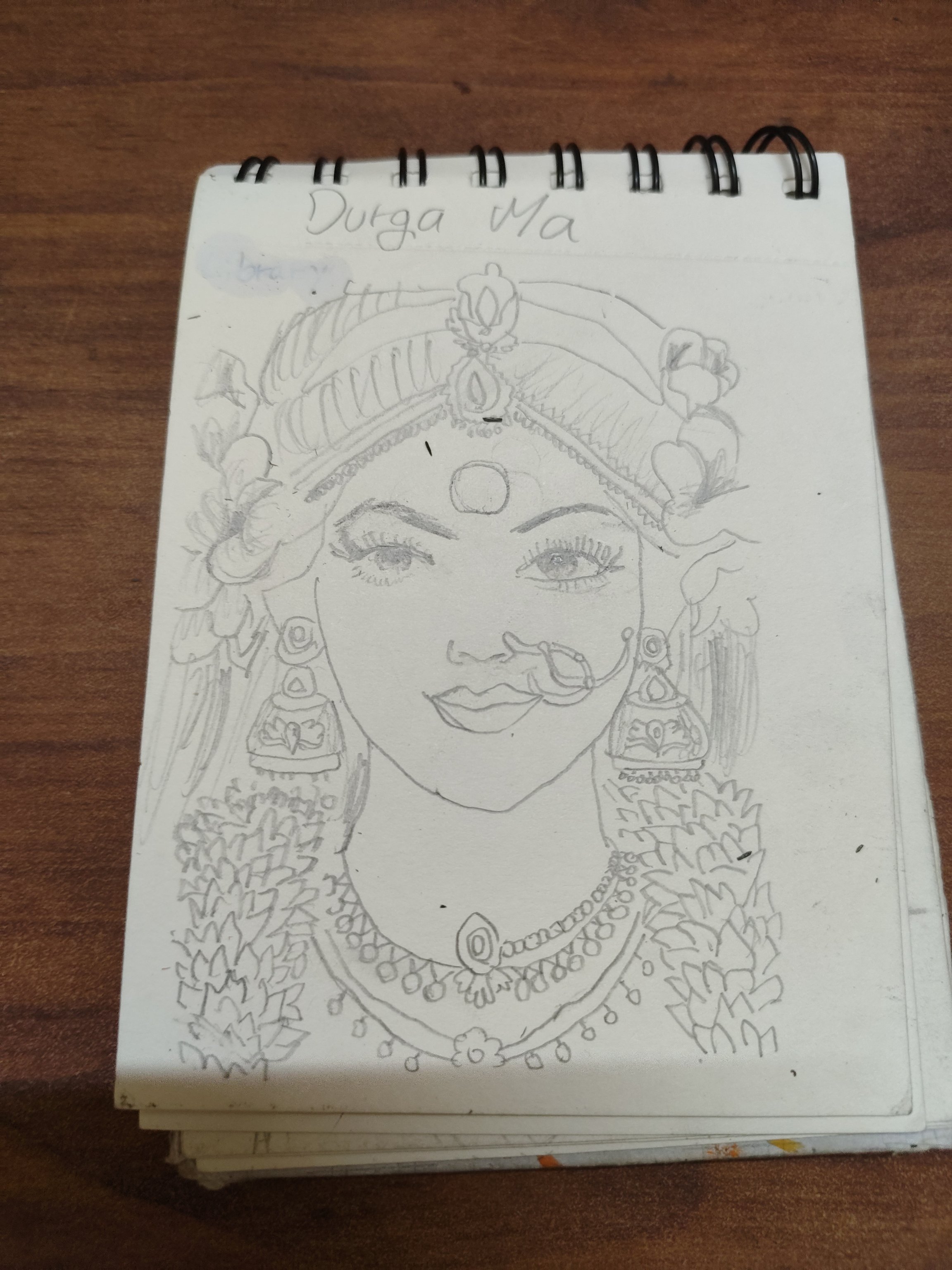 Boceto a lápiz de un retrato de diosa con marca redonda en la frente, tocado de joyas, pendientes y collar.